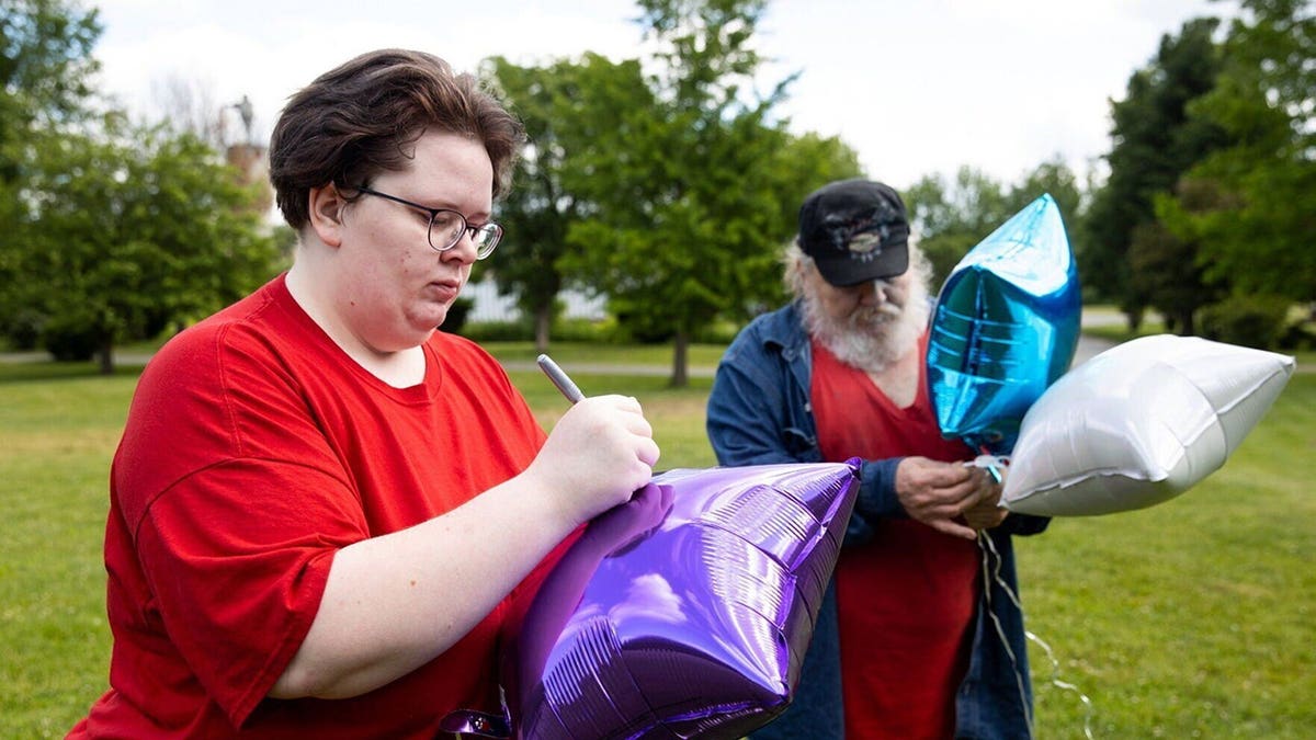 Kristan Newell writing on balloons before releasing them at Lazybrook Park in Tunkhannock, Pennsylvania