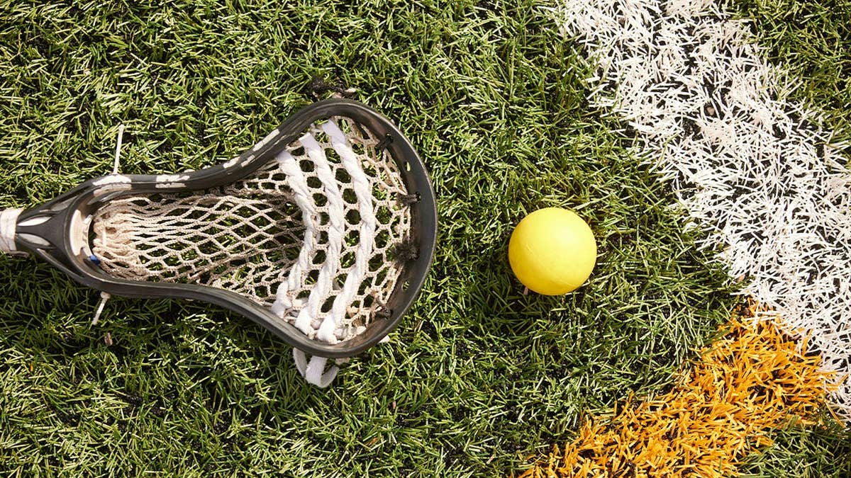 Close-up of lacrosse scoop and ball on the field