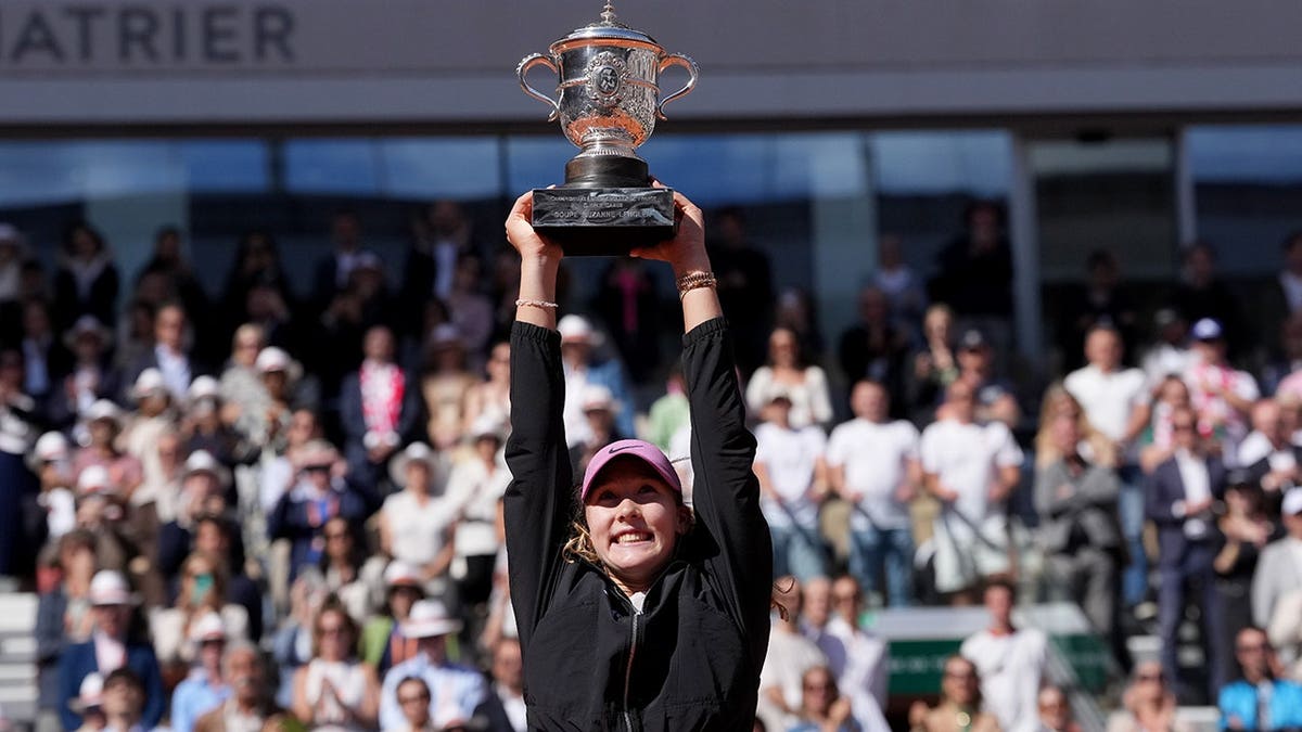 Mirra Andreeva holding trophy after winning tennis final