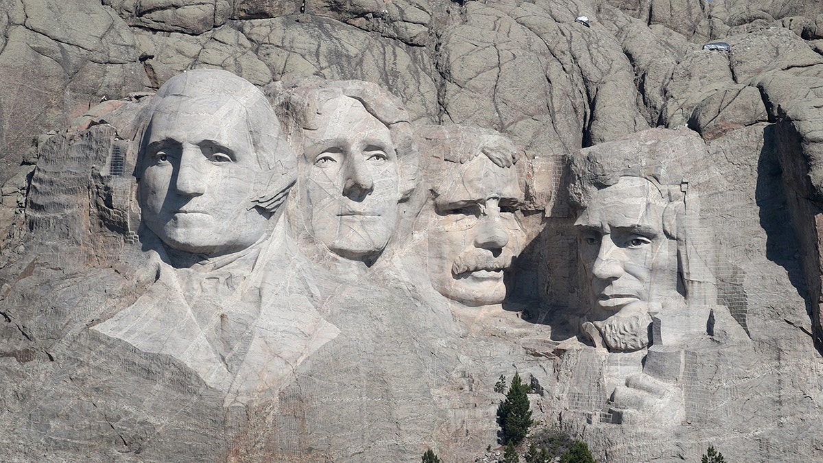 Busts of U.S. presidents George Washington Thomas Jefferson Theodore Roosevelt and Abraham Lincoln carved into Mount Rushmore