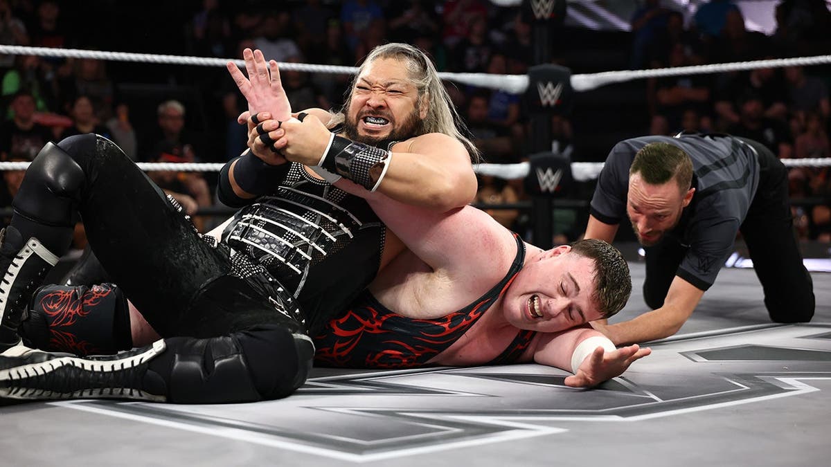 Naraku applying an arm-bar on Mason Rook during a wrestling match at the WWE Performance Center.