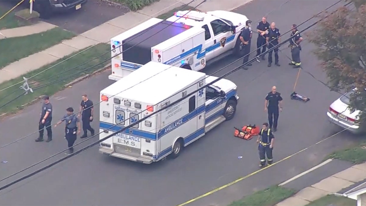 Police officers gathering at a crime scene outdoors.