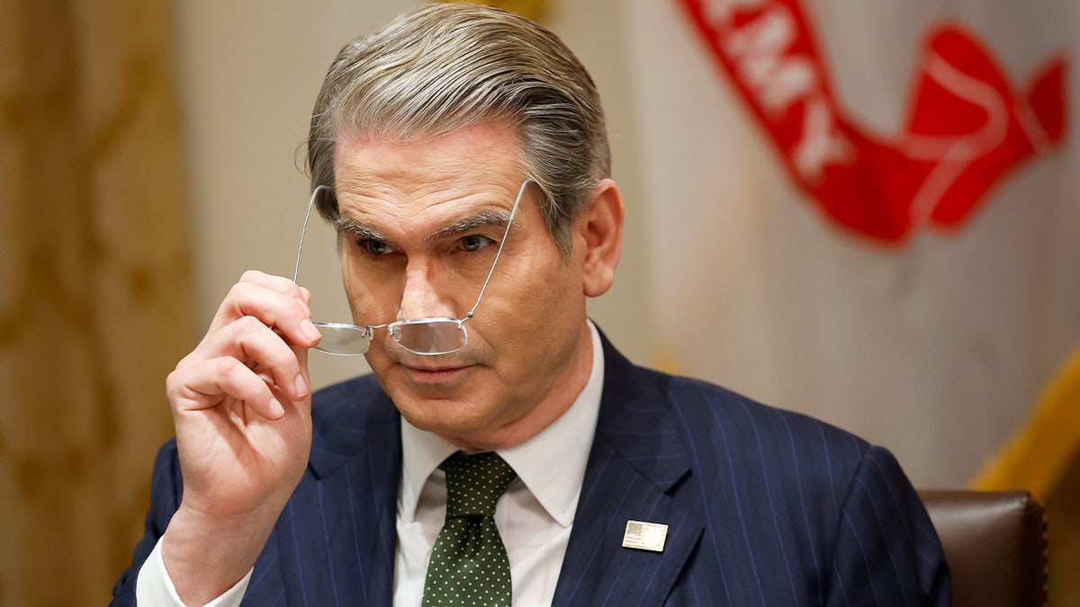 Treasury Secretary Scott Bessent adjusts his glasses during a White House meeting