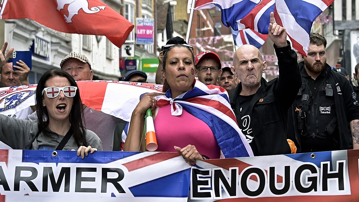 People carrying flags and banners gather at an anti-immigration protest in Maidstone, Kent