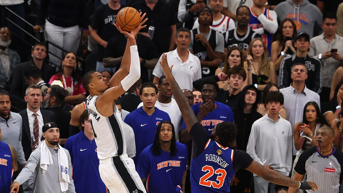 Victor Wembanyama shooting basketball against Mitchell Robinson in NBA Finals game