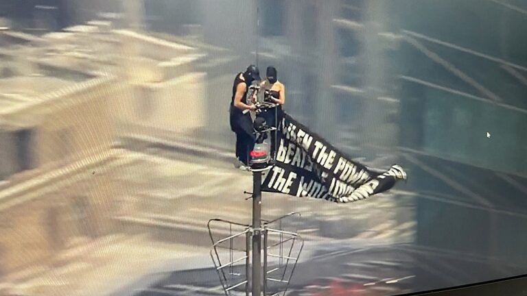 Two people climb to the top of Empire State Building with massive banner Two people climb to the top of Empire State Building with massive banner