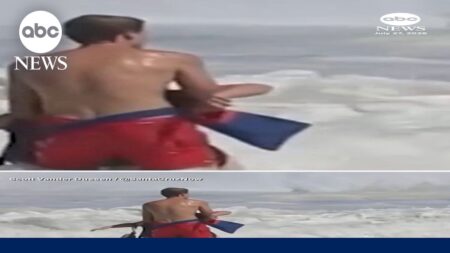 Lifeguard battles high surf to rescue swimmer