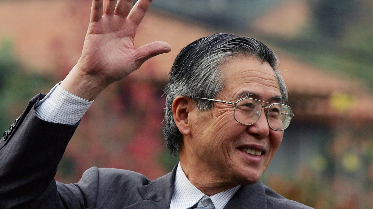 Former Peruvian President Alberto Fujimori waving outside his home in Santiago