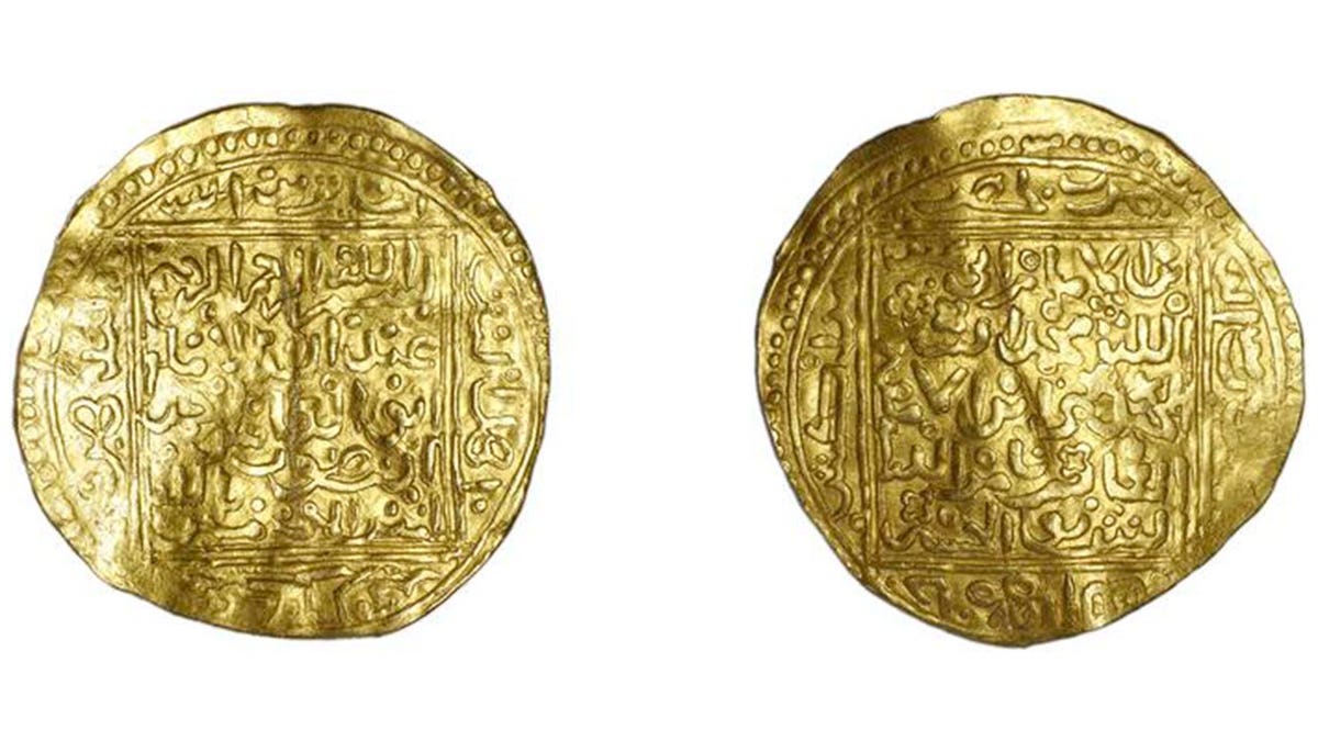 Moroccan gold coins on display with Arabic writing