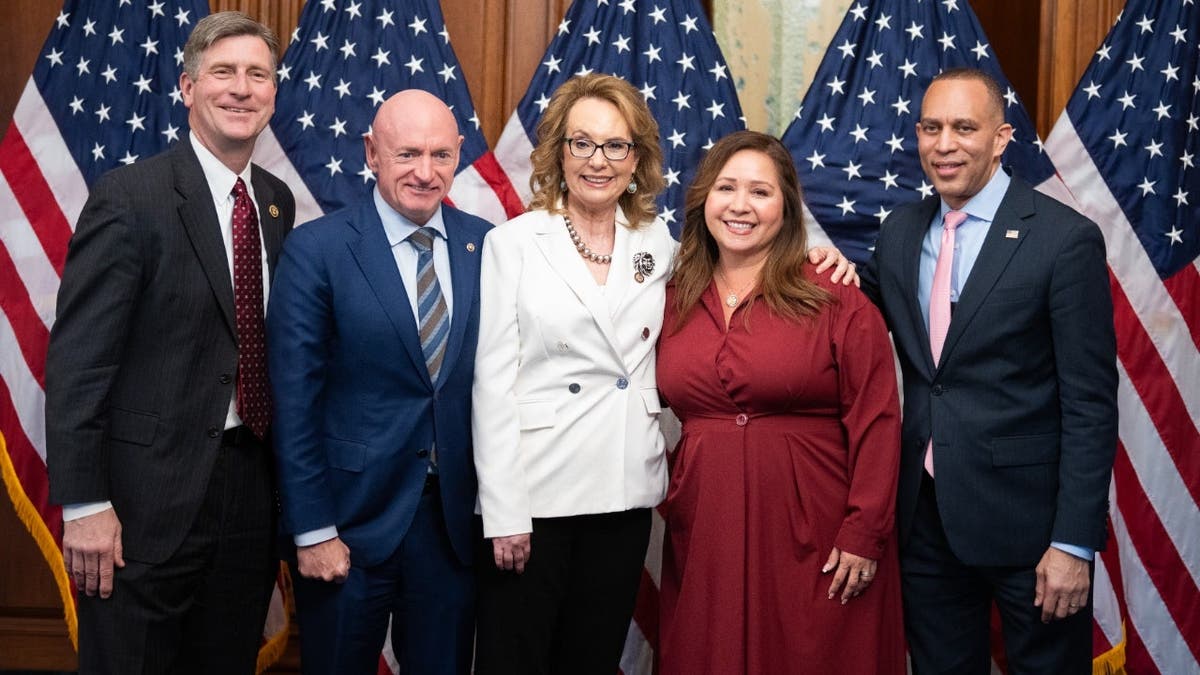 Former Rep. Gabby Giffords, D-Ariz., center, her husband Sen. Mark Kelly, D-Ariz., second from left, Reps. Greg Stanton, D-Ariz., left, Adelita Grijalva, D-Ariz. and House Minority Leader Hakeem Jeffries, D-N.Y., pose for a photo in the U.S. Capitol after a joint resolution was introduced to honor the six people killed in 2011 in Tucson on the 15th anniversary of the shooting that also injured Giffords, on Thursday, January 8, 2026. (Tom Williams/CQ-Roll Call, Inc via Getty Images)