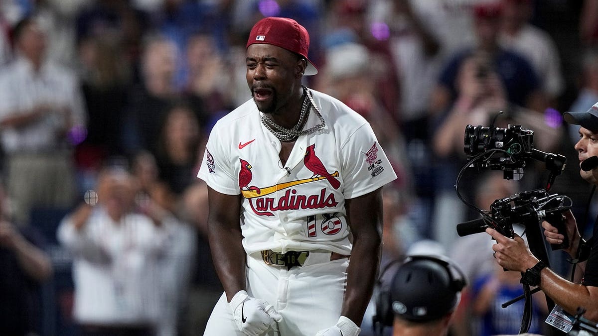 Jordan Walker celebrates with arms raised in a baseball stadium.