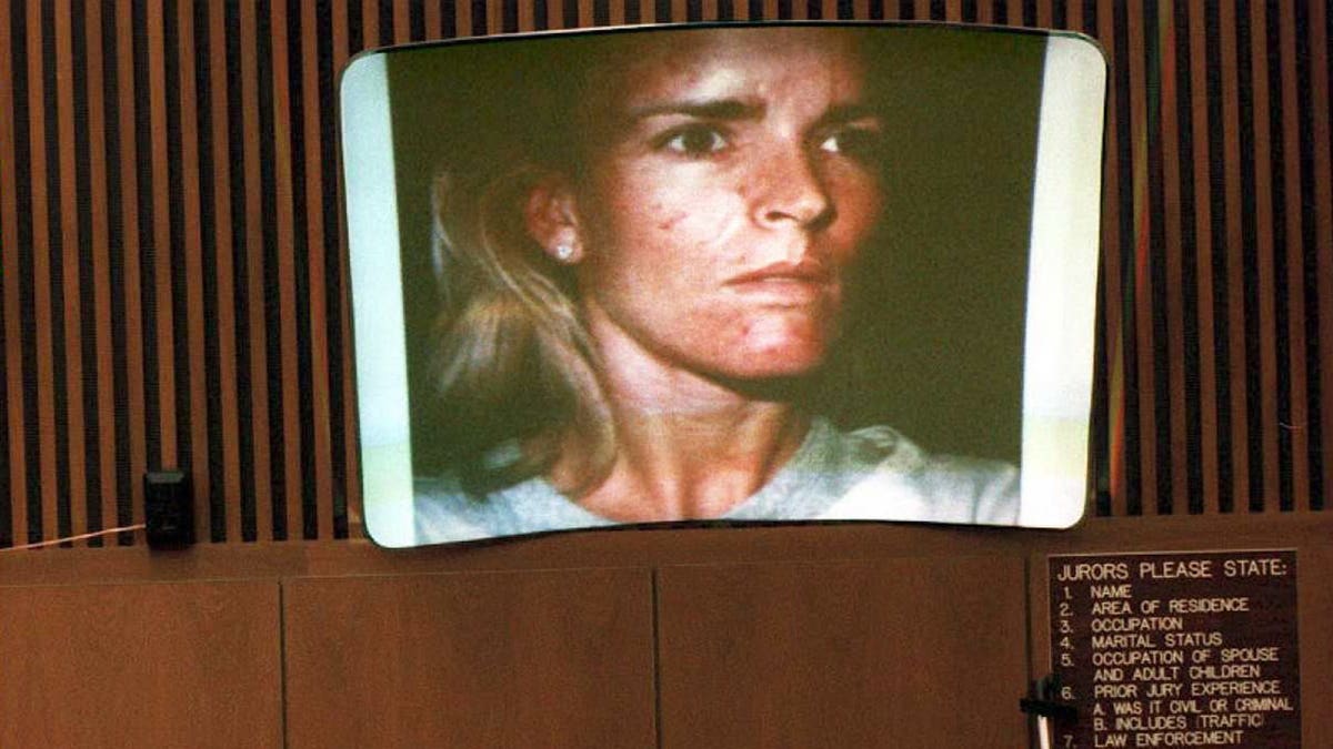 Denise Brown cries on the witness stand in a courtroom.