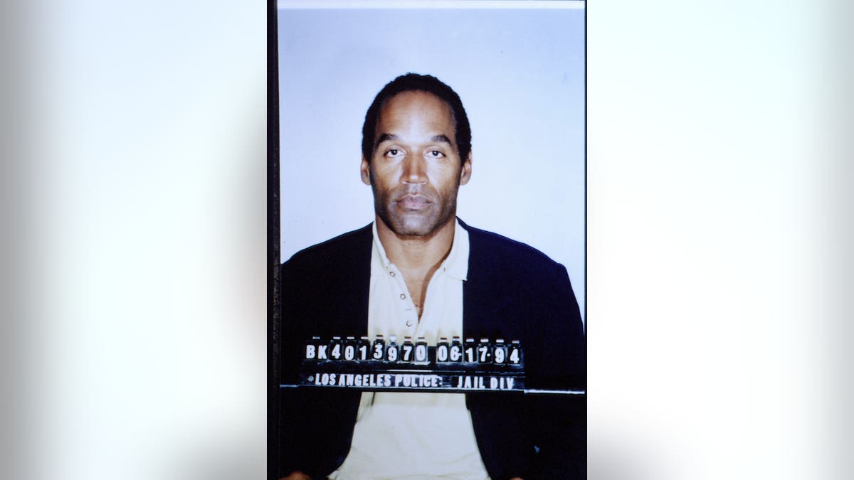 O.J. Simpson stands during his trial in a courtroom.