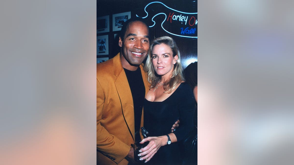 O.J. Simpson stands with his arm around Nicole at a cafe opening.