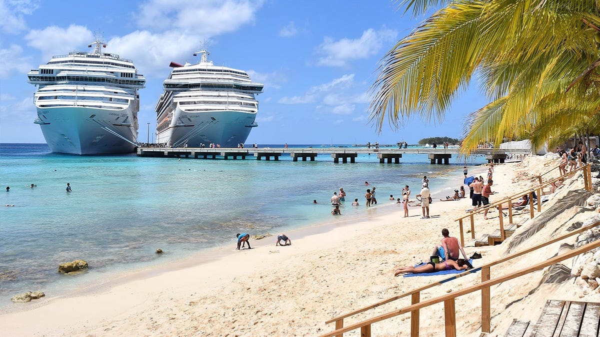 Beachgoers standing on Turks and Caicos beach with cruise ship in background