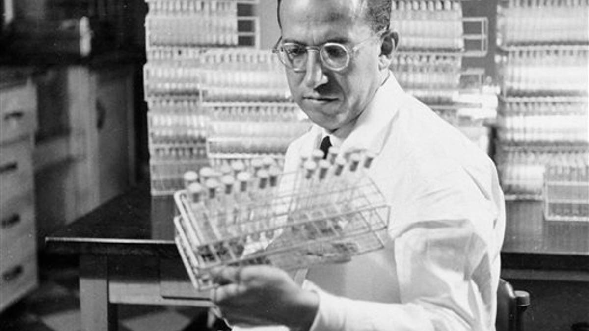 FILE - In this Oct. 7, 1954 file photo, Dr. Jonas Salk, developer of the polio vaccine, holds a rack of test tubes in his lab in Pittsburgh, Pa. (AP Photo/File)