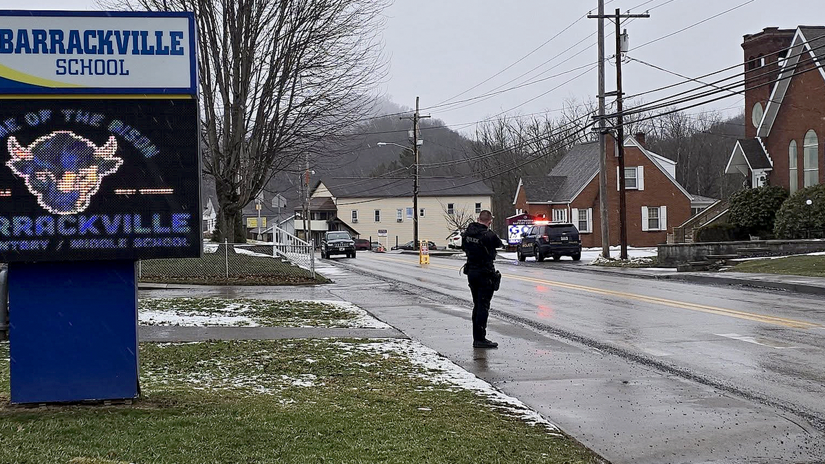 Barrackville police officer and patrol vehicles on a street in Barrackville, West Virginia.
