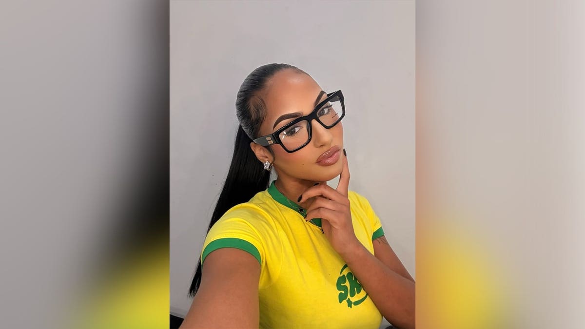 Woman in yellow shirt and wearing glasses posing