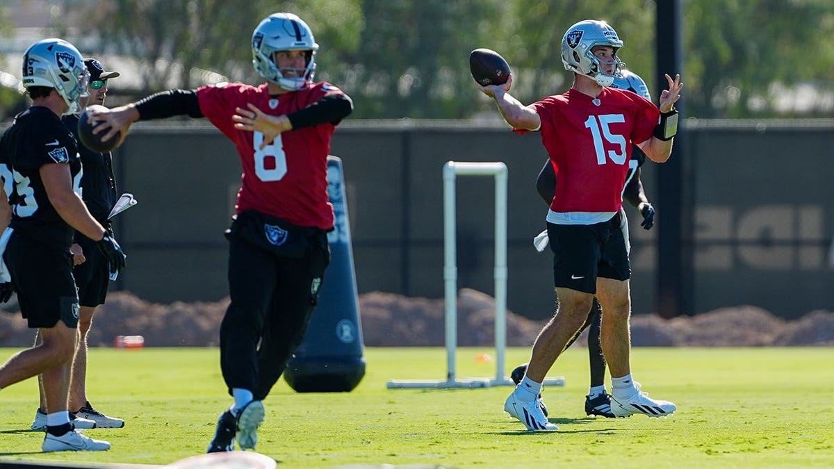 Kirk Cousins #8 and Fernando Mendoza #15 warm up during Las Vegas Raiders minicamp.