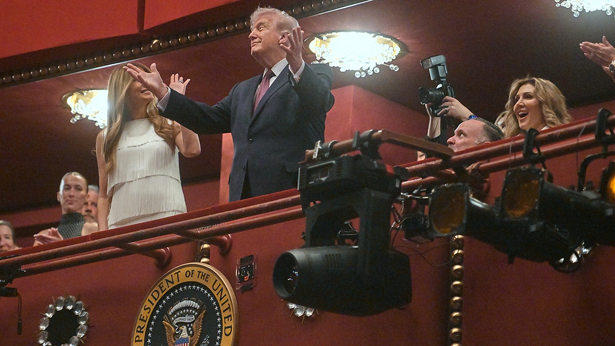 Donald Trump and Melania Trump standing together as they arrive at a theater.