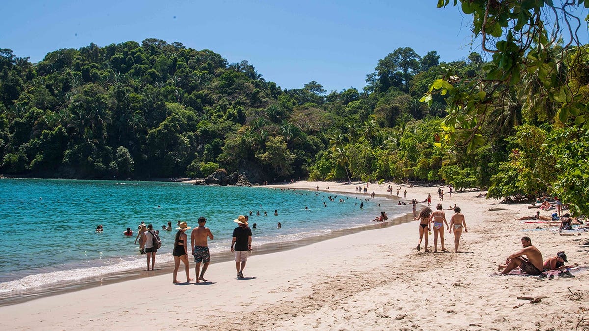 People enjoy sunshine on a beach in Manuel Antonio National Park, Quepos, Costa Rica.