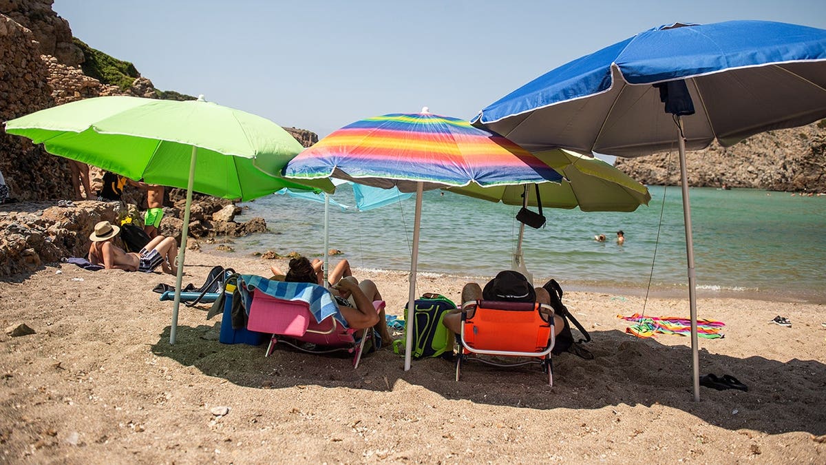 Umbrellas line the beach at Cala Domestica in Buggerru, Italy.