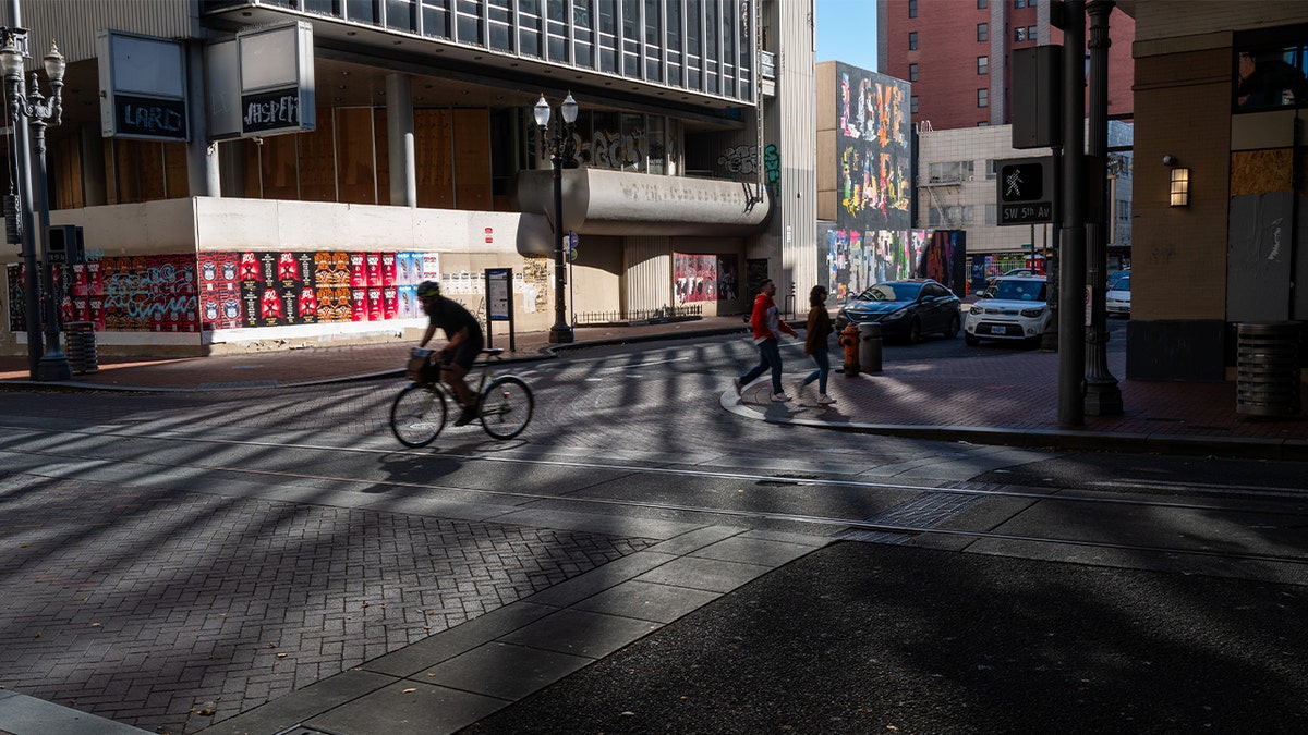 man rides bike through downtown portland streets