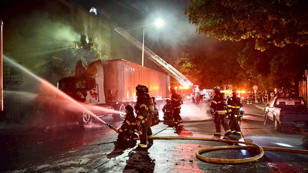 Firefighters spraying water on a fire