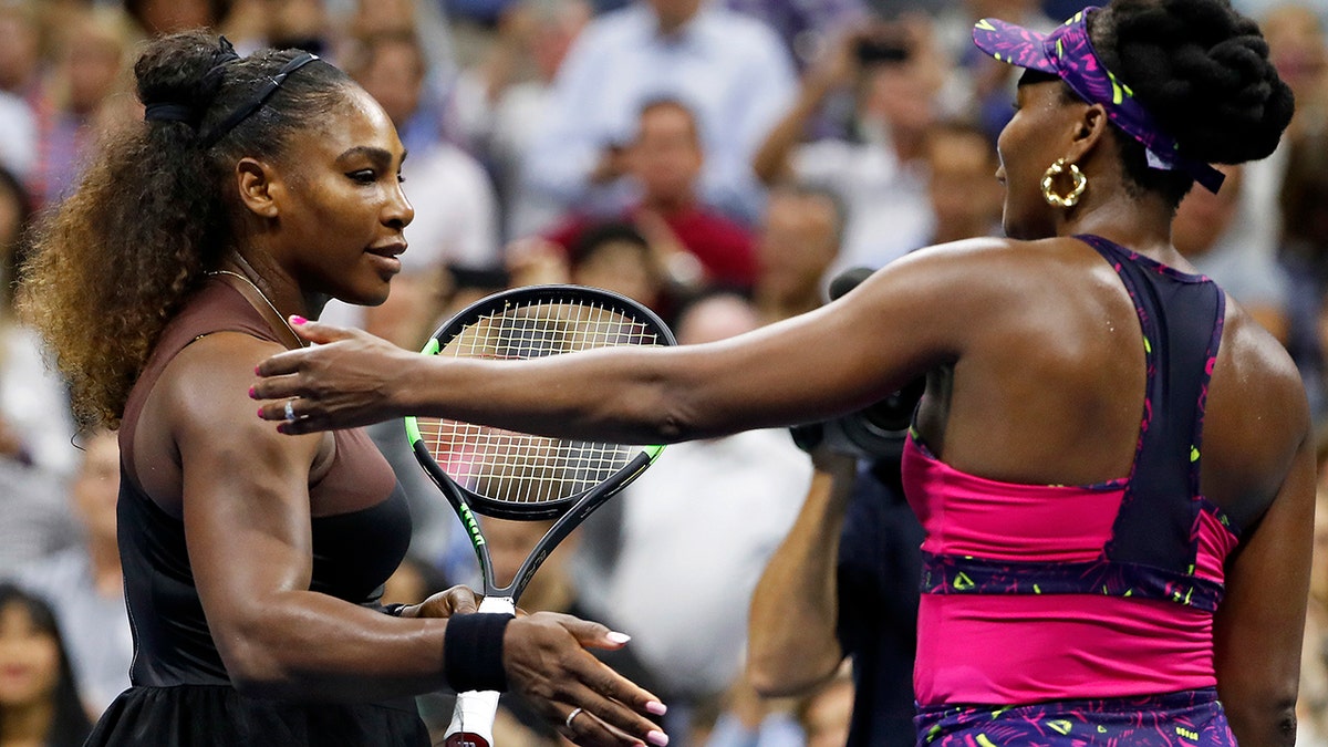 Serena Williams, left, meets her sister Venus Williams after their match during the third round of the U.S. Open tennis tournament, in Flushing, N.Y., Aug. 31, 2018.