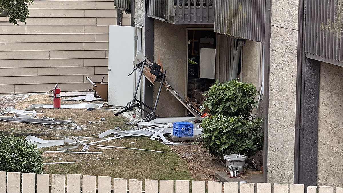 Firefighters and a police officer stand outside a Tacoma apartment complex after an explosion prompted evacuations.