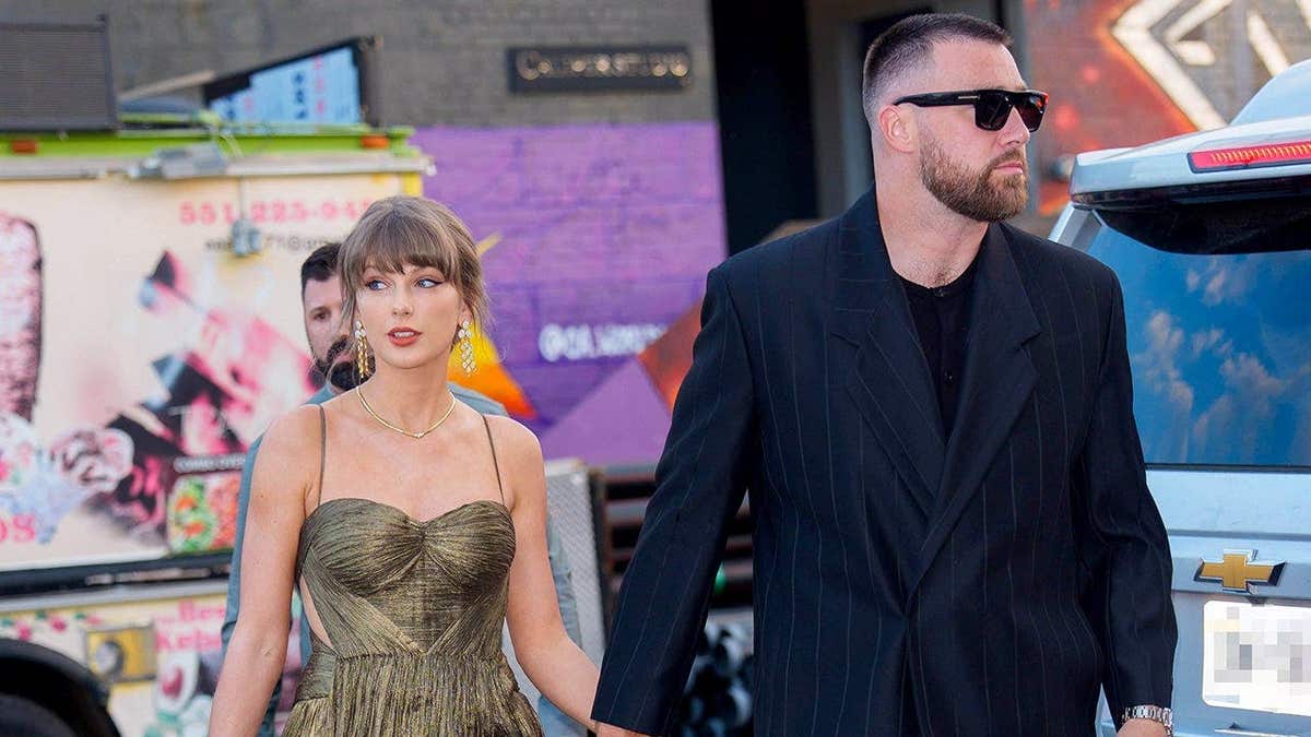 Taylor Swift walks hand-in-hand with Travis Kelce.