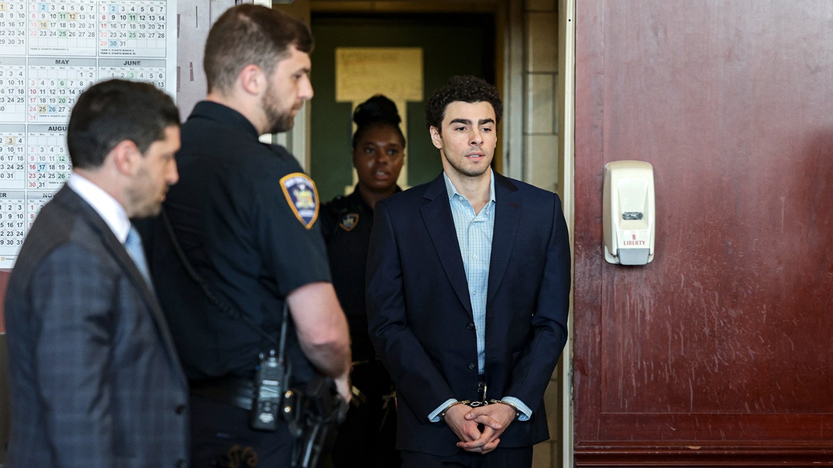 Luigi Mangione arriving for an evidence suppression hearing in a courtroom.
