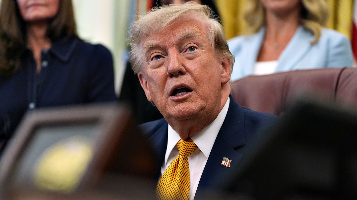 President Donald Trump speaks while sitting at Resolute Desk
