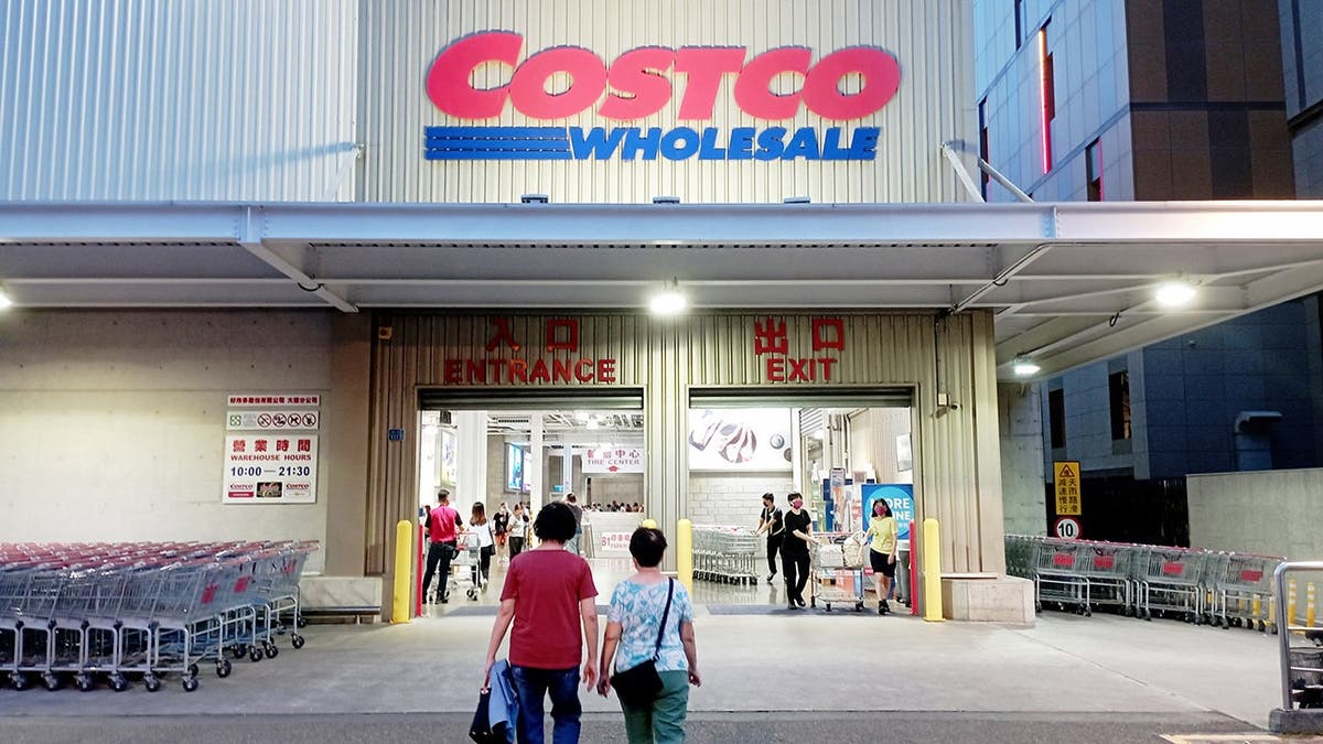 People walk into a Costco store.