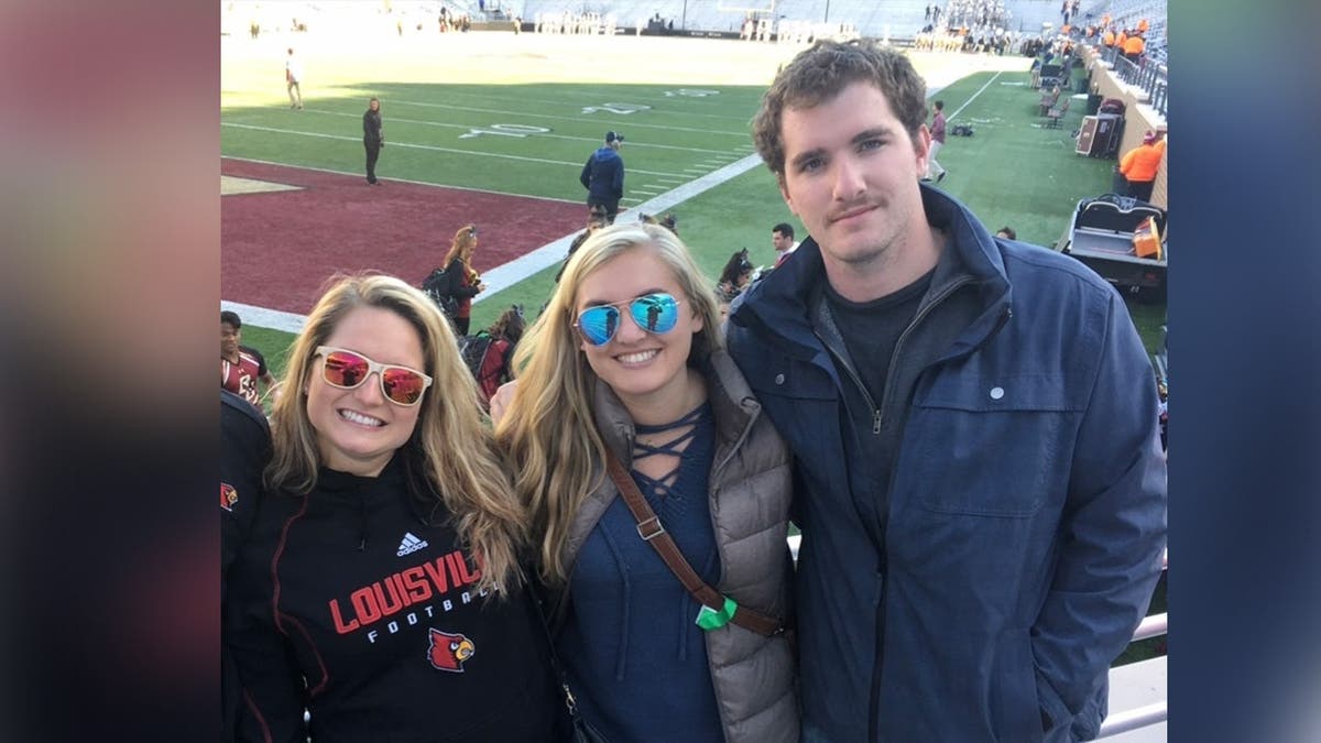 photo shows the three people posing for a photo