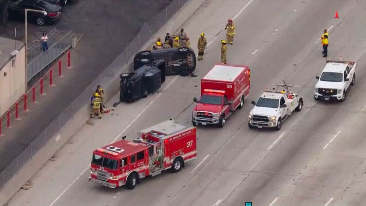 Emergency crews surround two overturned cars following a crash on the 405 Freeway in Los Angeles