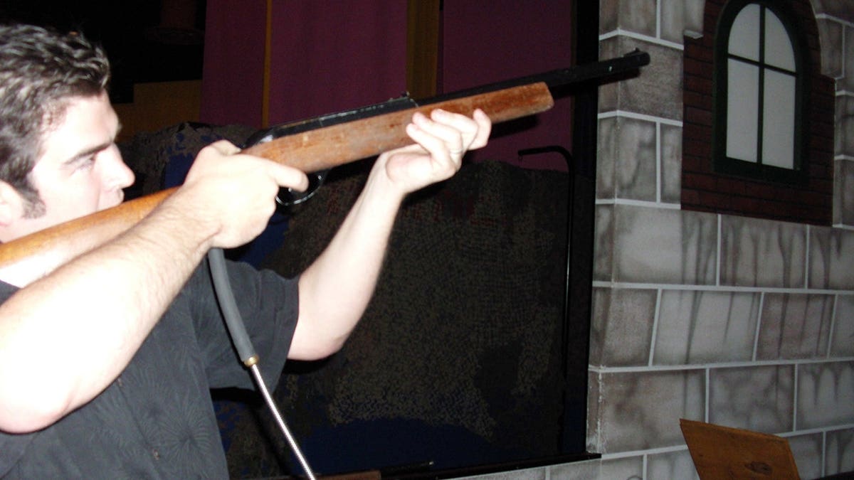 Daniel Wozniak holding a shotgun away from the camera.