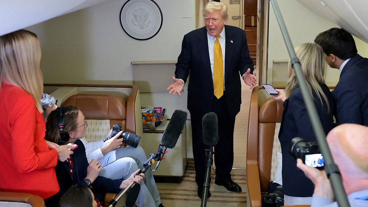 Donald Trump speaks to reporters in the press cabin of Air Force One.