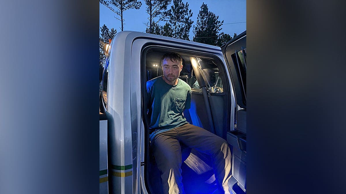 Drake Ladon Keef sits inside a law enforcement vehicle after being taken into custody.