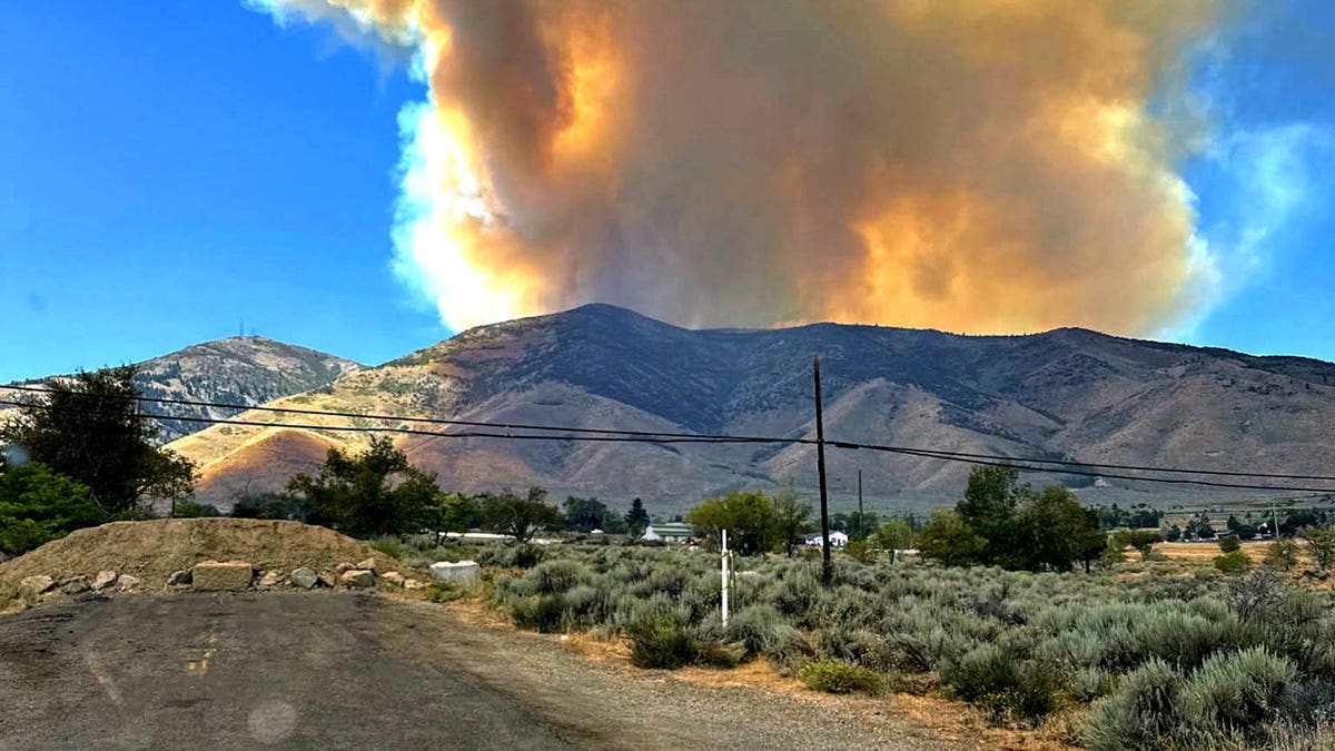smoke rising in the distance over mountainous area