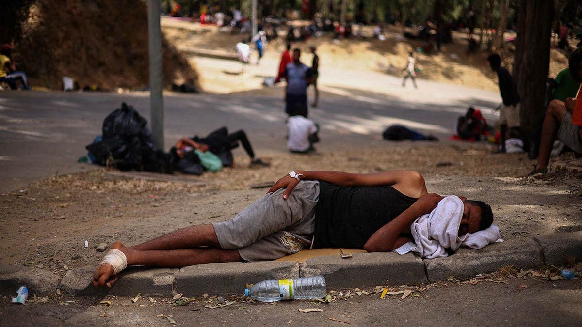 Migrants wait outside Ceuta's temporary migrant cente