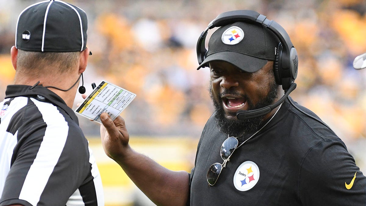 Pittsburgh Steelers head coach Mike Tomlin, right, talks to an official during the first half of a preseason NFL football game against the Seattle Seahawks, Saturday, Aug. 13, 2022, in Pittsburgh.