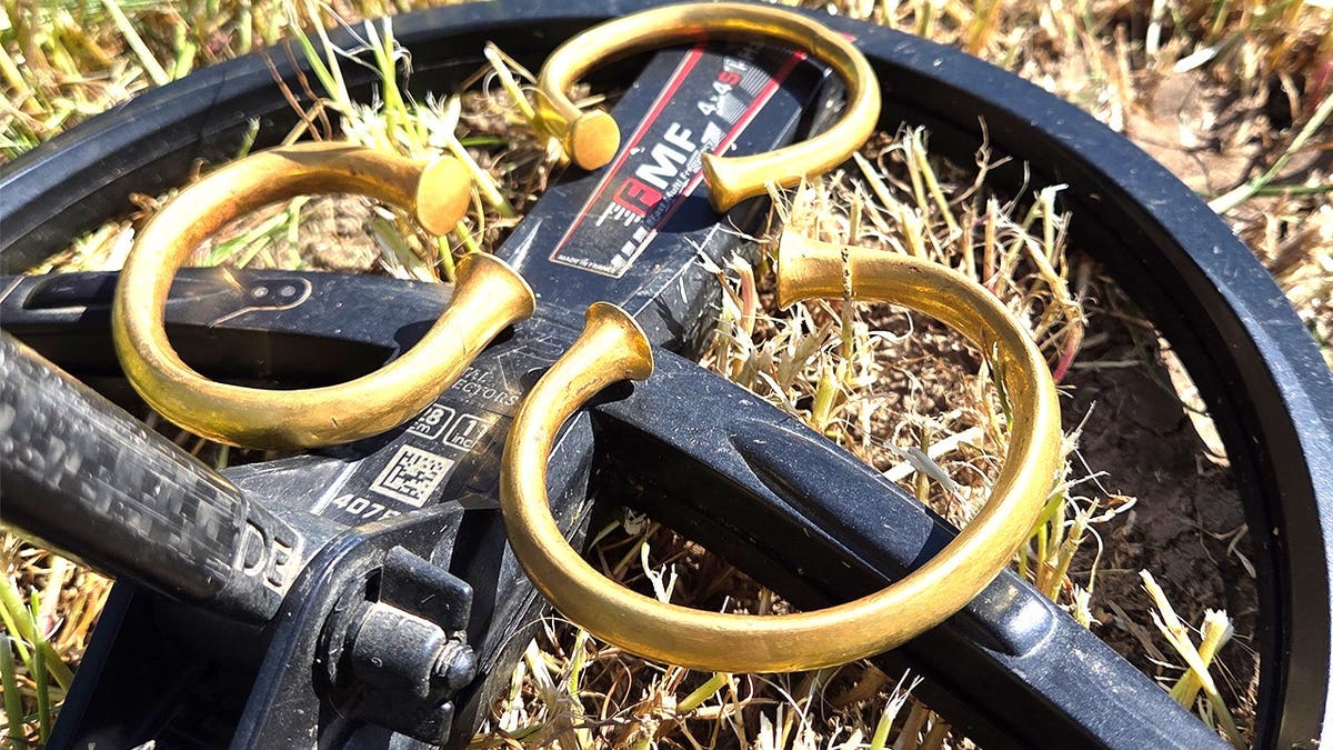 three gold torcs laying on top of metal detector