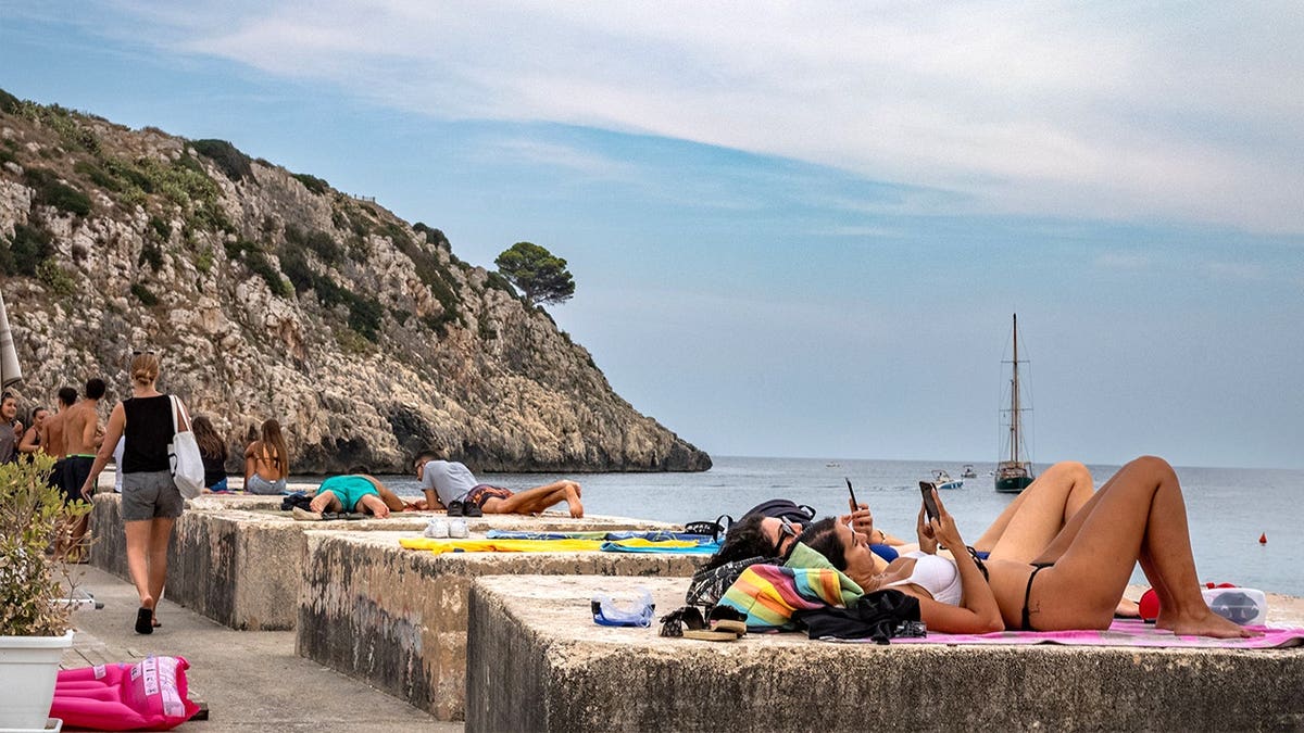 People in Italy sunbathing on beach