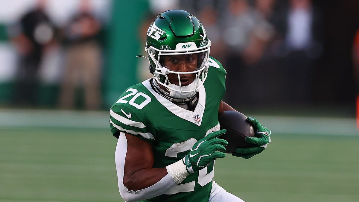 Breece Hall, number 20, runs with the ball during a Jets game.