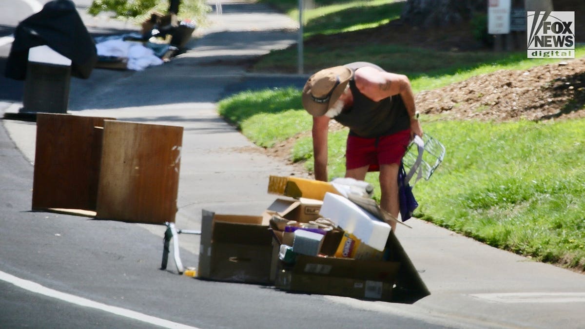 Brian Hooker rummages through neighborhood trash in California.