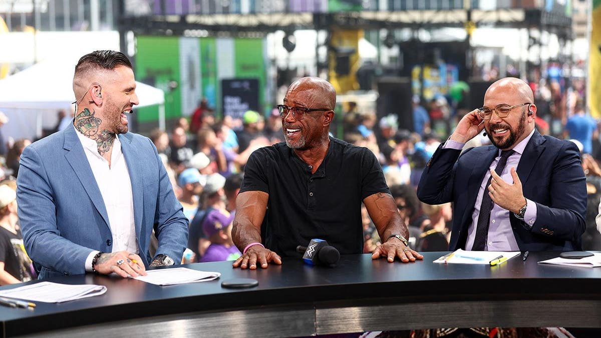 Corey Graves, Darius Rucker and Peter Rosenberg smile at WWE Countdown during SummerSlam