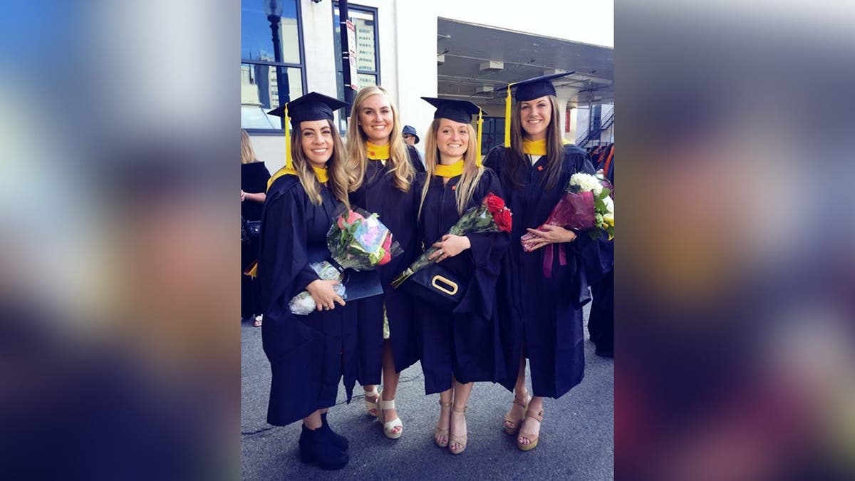 Four friends pose for a photo on graduation day at Northeastern University in Boston.