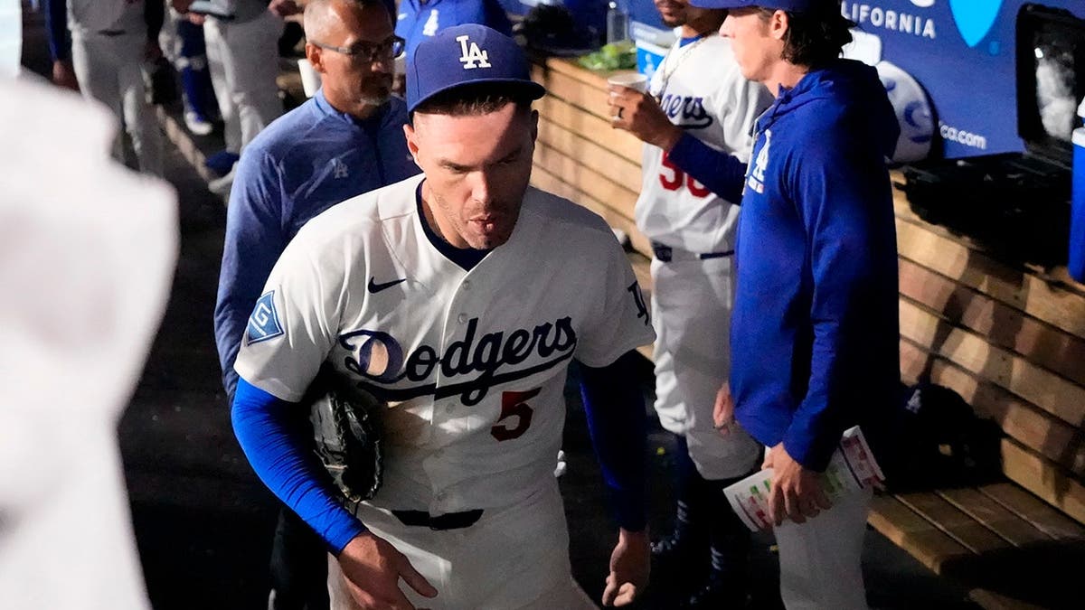 Freddie Freeman leaves the field after falling into the visitors dugout while attempting to catch a foul ball.