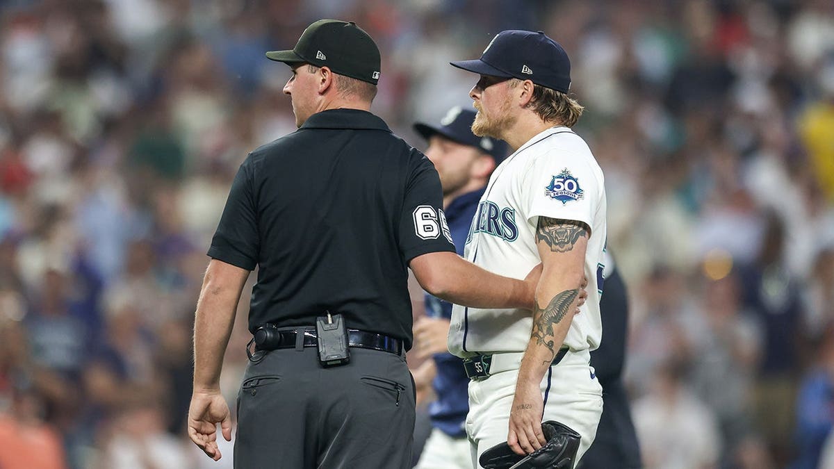 Gabe Speier is held back on the field during a Mariners-Tigers game at T-Mobile Park.